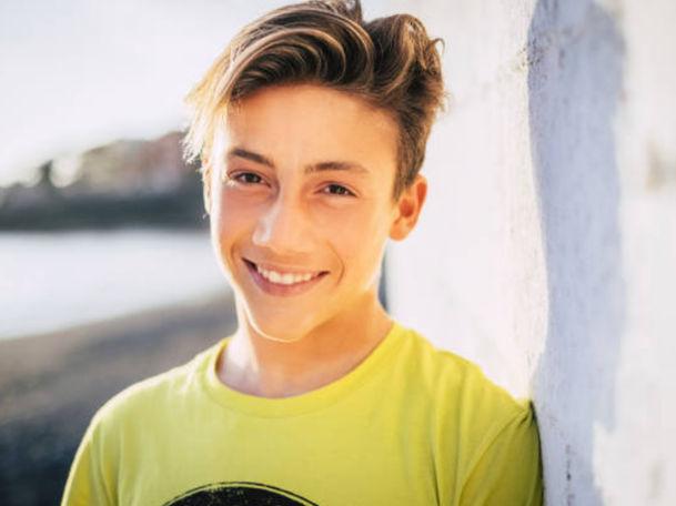 Original outdoor casual European teenage boy portrait, sunny beach background, lime green T-shirt, relaxed natural pose, bright smile, natural light photography, 4:3 ratio AI Stencil style comparison reference