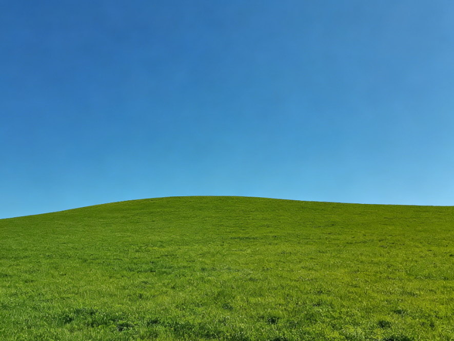 Outdoor natural scenery photo with blue sky and green grass, bright light, simple composition, fresh realistic style, no sticker decoration, 4:3 aspect ratio photography