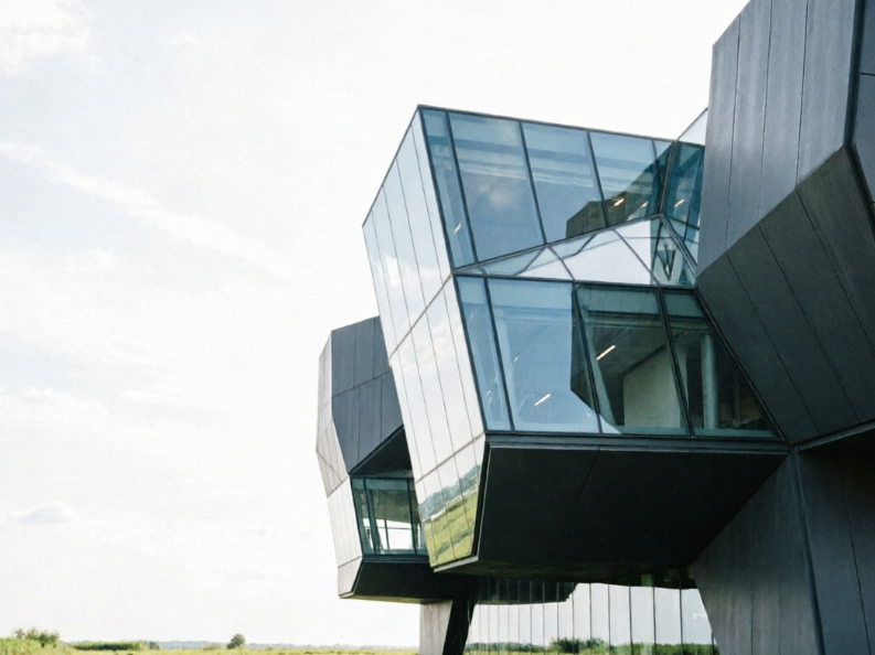 where the building's main structure now leans towards the right side of the frame, with the left-right elements of its glass and steel entirely reversed, and the sky and green area also flipped accordingly, creating a curious visual effect that is both symmetrical and familiar. 