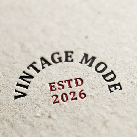 1:1 ratio. High-detail macro shot of off-white art paper with a subtle fiber texture. The logo "VINTAGE MODE" is printed in bold black ink in a semi-circular arc. Below, a small red "ESTD 2026" is neatly centered. Soft natural side-lighting emphasizes the slight ink depression on the paper surface.