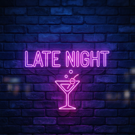1:1 ratio. A glowing pink and purple neon sign on a dark blue brick wall at night. The neon tubes form the words "LATE NIGHT" with a small illuminated cocktail glass icon below. A soft purple haze reflects off the brick surface, creating a film-like cinematic atmosphere.