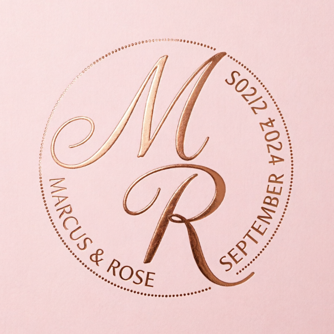 A 1:1 delicate wedding monogram. Two interlocking letters 'M' and 'R' in a fine, hand-drawn cursive. A thin, dotted circular frame holds the names 'MARCUS & ROSE' and the date 'SEPTEMBER 2024'. Rose gold color on a soft blush pink background.