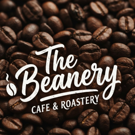 A 1:1 cozy cafe logo branding. The name "The Beanery" written in a casual, marker-style signature font. The logo is printed in white on a dark roasted coffee bean background. The contrast is high, and the typography feels warm, approachable, and artisanal.